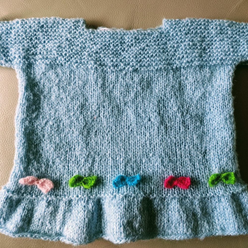 Hand knitted light blue dress in mohair with multi color bows